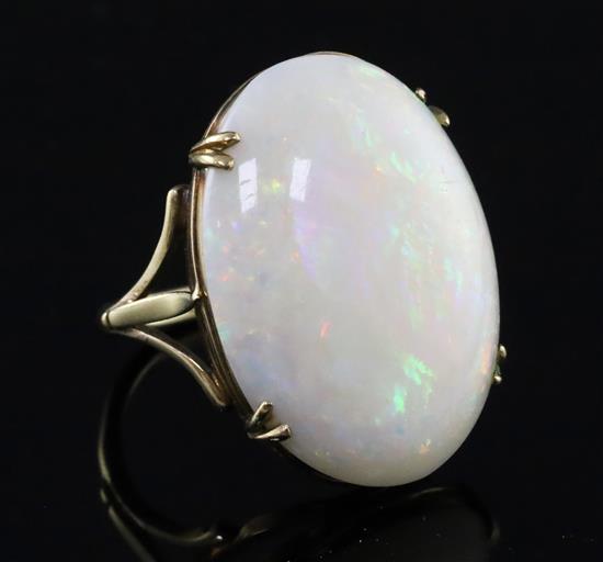A 9ct gold and oval white opal set dress ring, gross weight 7 grams.